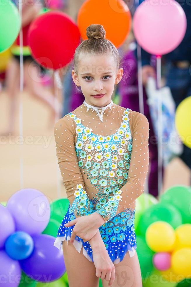 Beautiful little active gymnast girl with her performance on the carpet photo