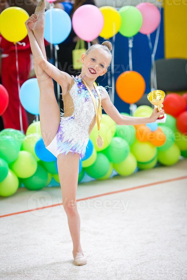 Beautiful little active gymnast girl with her performance on the carpet photo