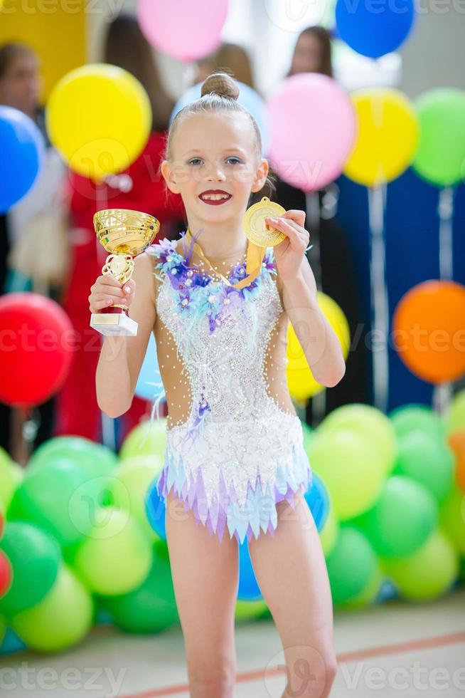 hermosa niña gimnasta activa con su actuación en la alfombra foto