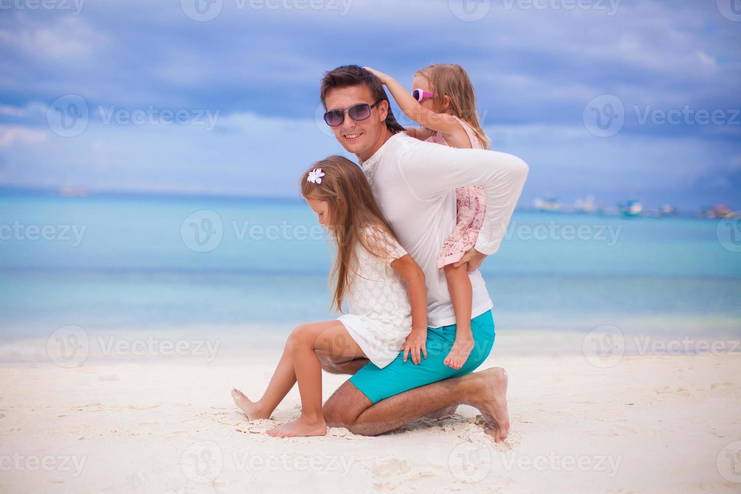 Happy father and his adorable little daughters have fun on sunny day photo