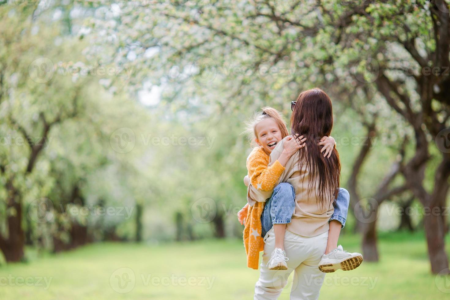 familia de madre e hija en el floreciente jardín de cerezos foto