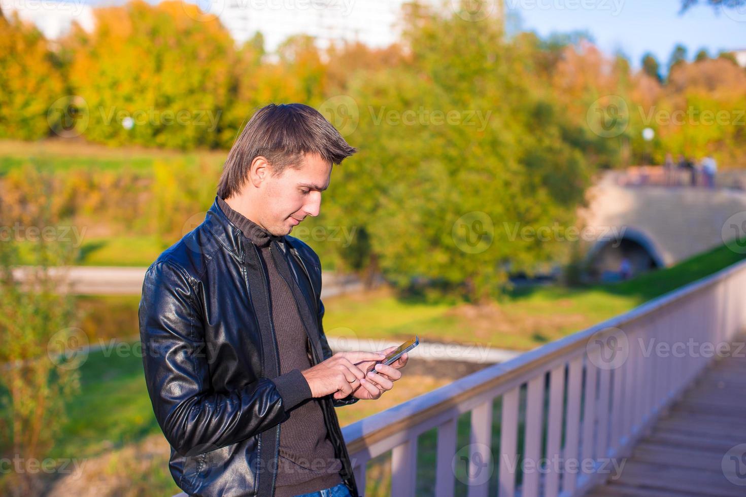 Young man with a phone in the park photo