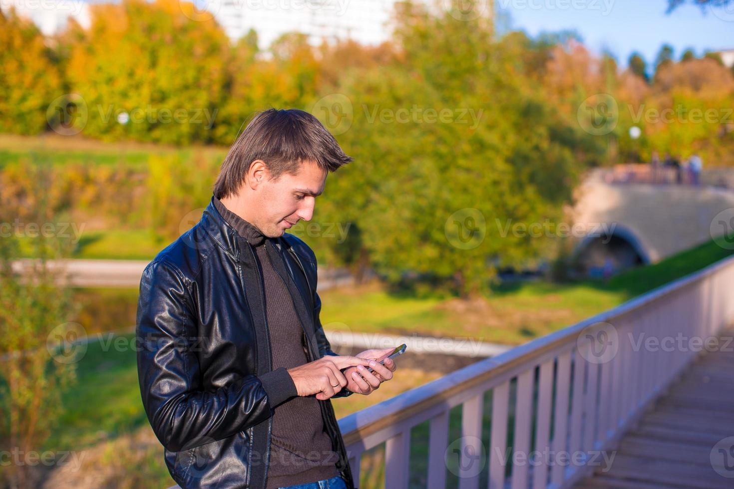 Young man with a phone in the park photo