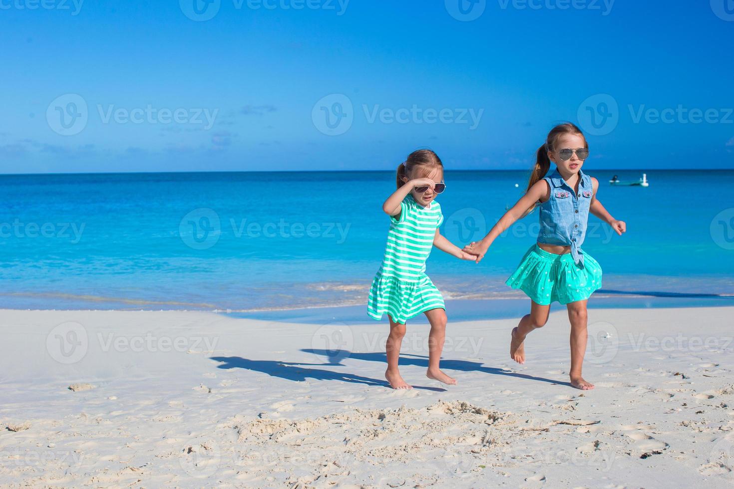 niñas divirtiéndose durante las vacaciones en la playa tropical foto