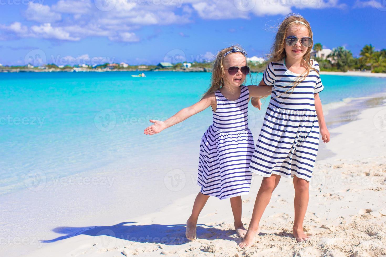 Adorable little girls enjoying summer beach vacation photo