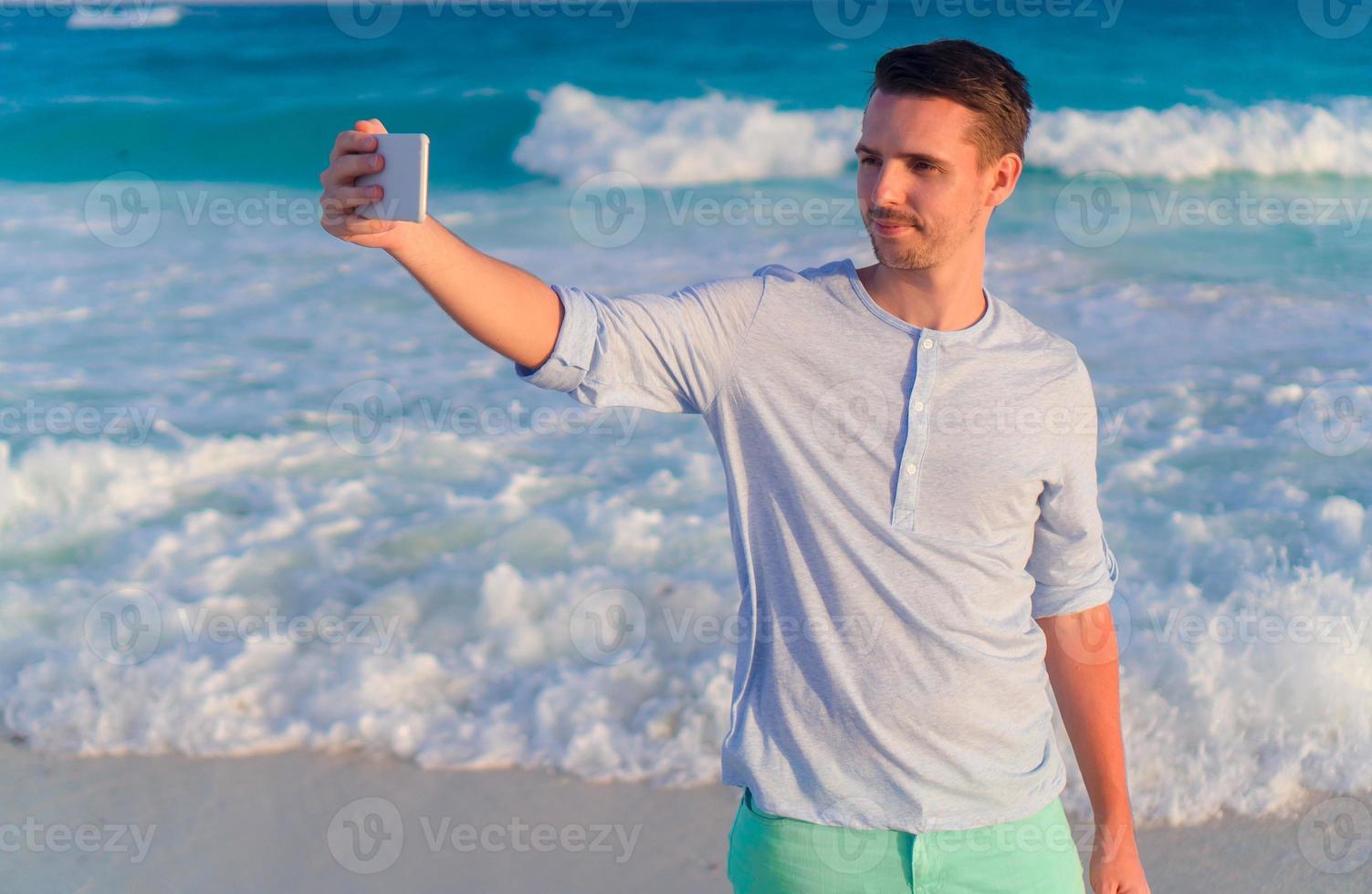 Young man taking selfie on the beach background the sea photo