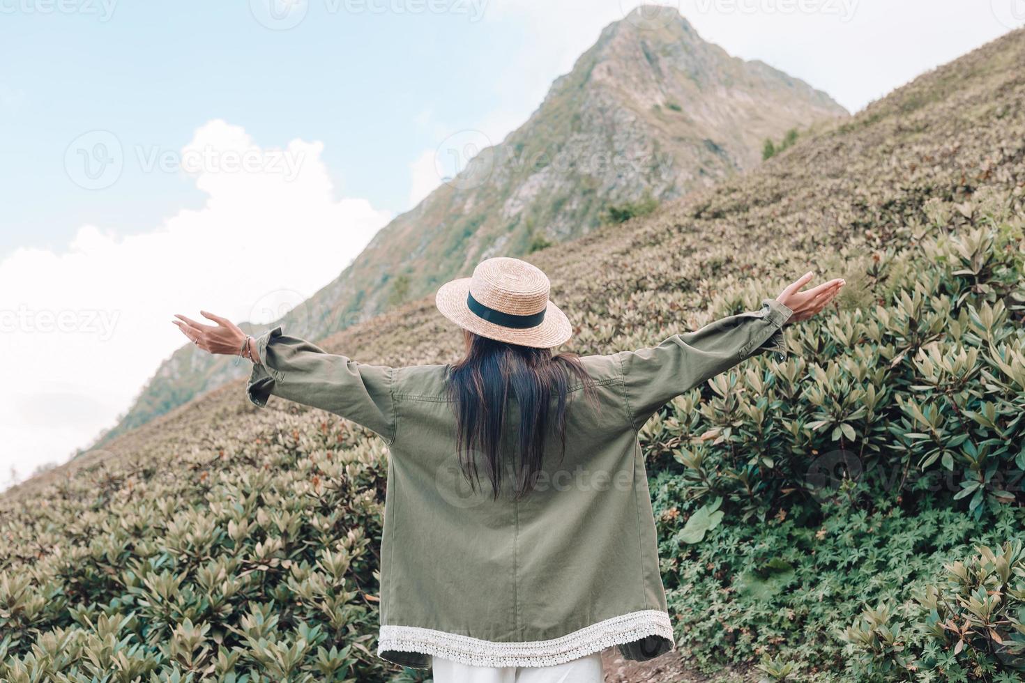 Beautiful happy young woman in mountains in the background of fog photo