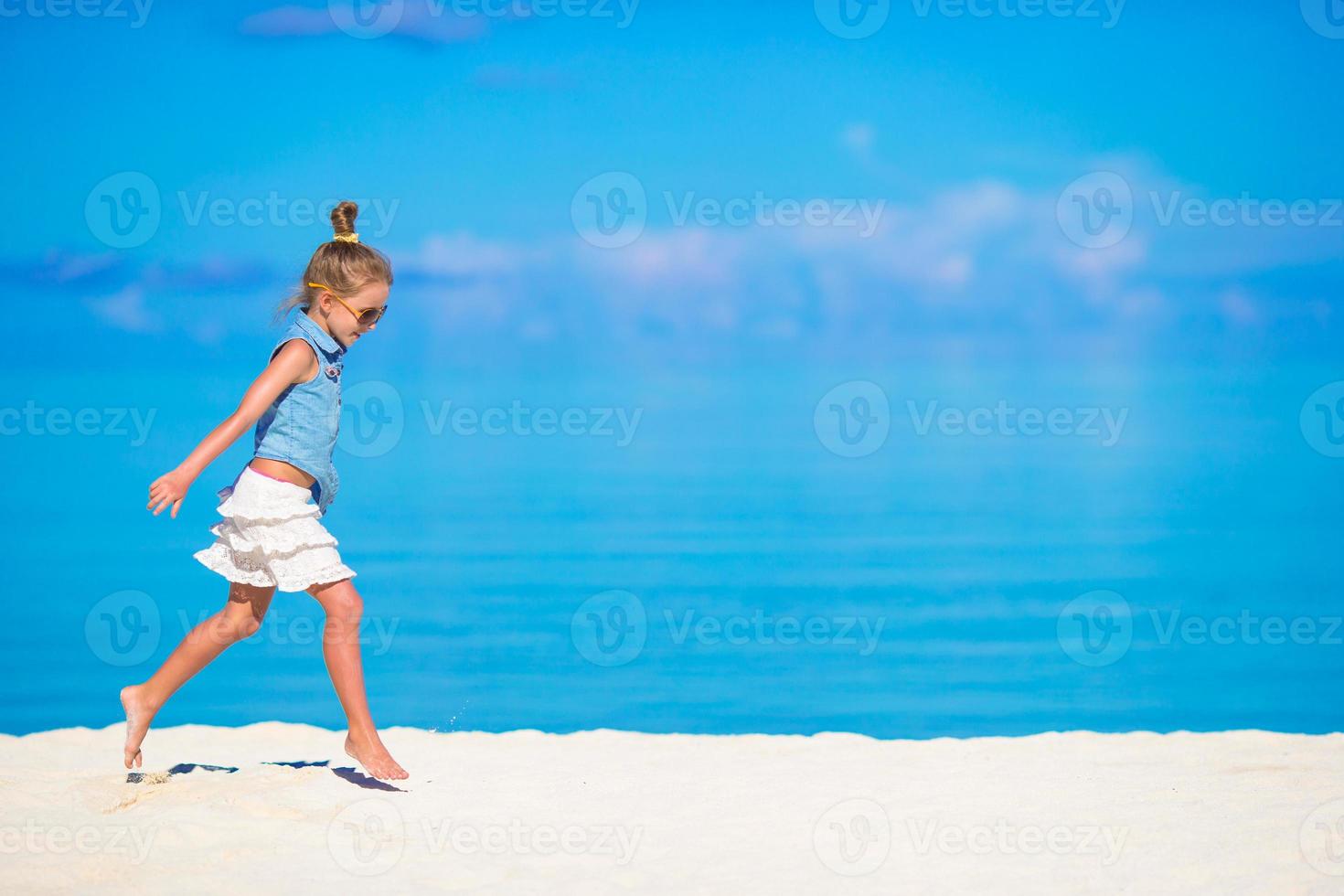 Adorable little girl during beach vacation having fun photo