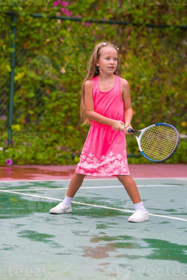 niña jugando tenis en la cancha foto