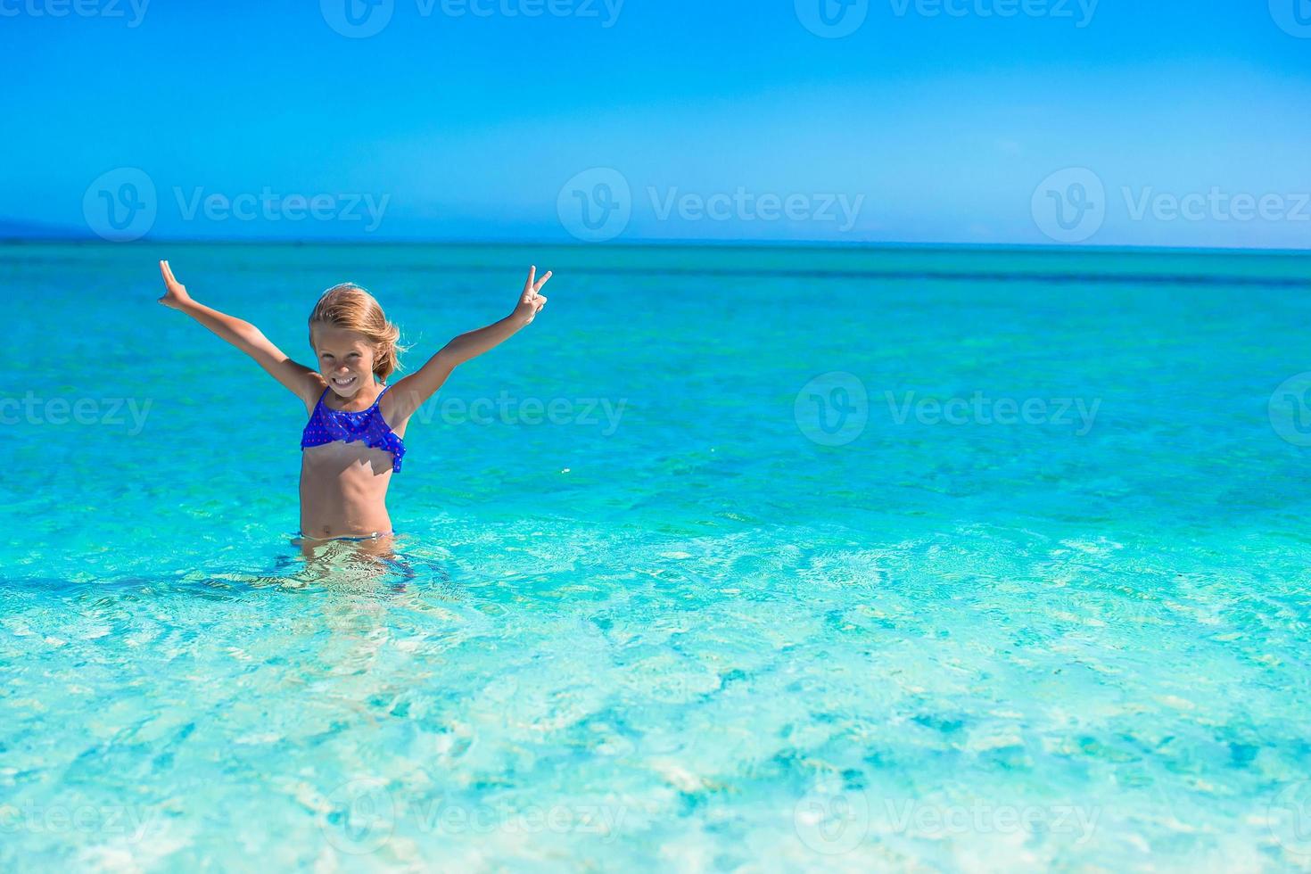 Little happy girl enjoying beach vacation photo