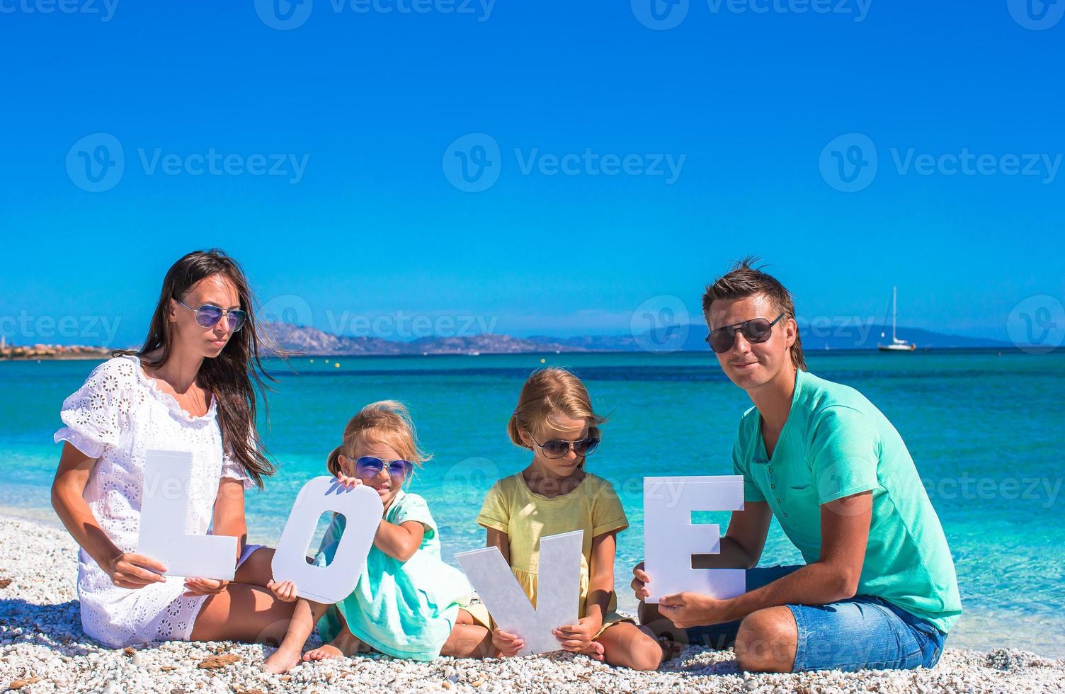 Happy family of four during summer beach vacation photo