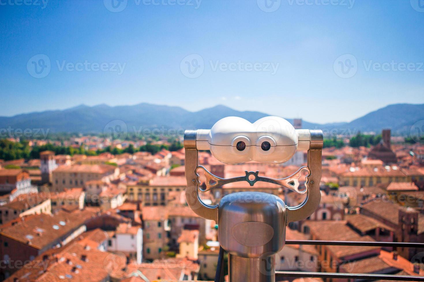 telescopio turístico mira la pequeña ciudad italiana. cerrar binoculares de metal en el punto de vista de fondo con vistas a la montaña foto