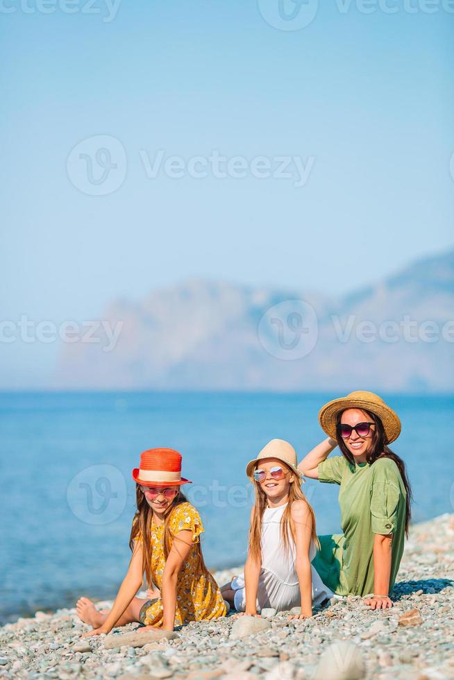 Adorable little girls and young mother on tropical white beach photo