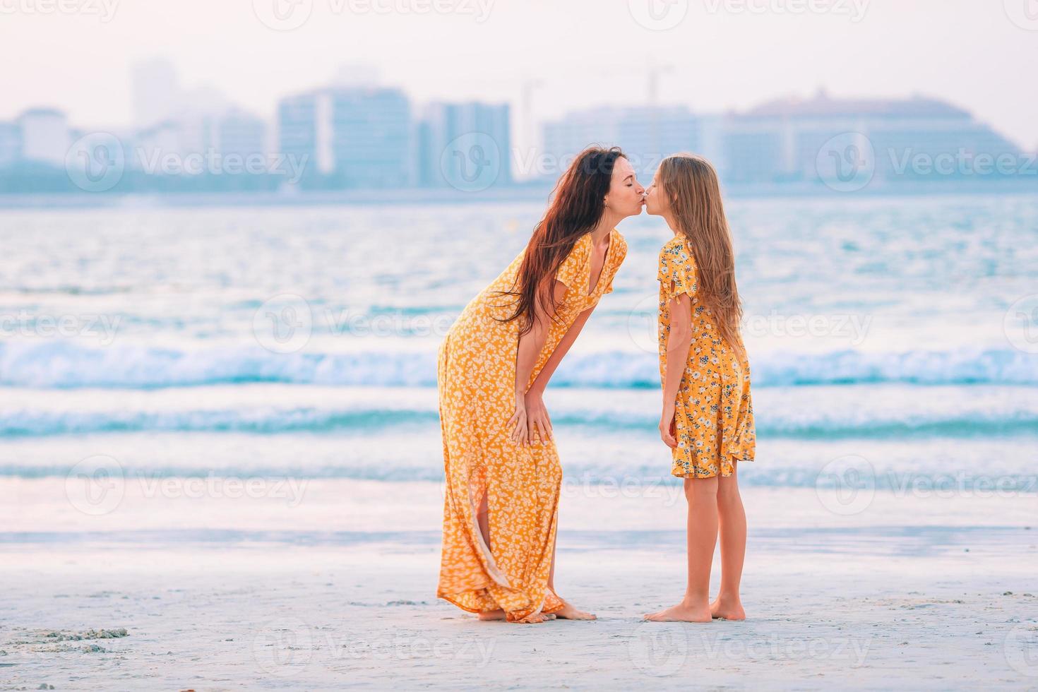 hermosa madre e hija en la playa disfrutando de las vacaciones de verano. foto