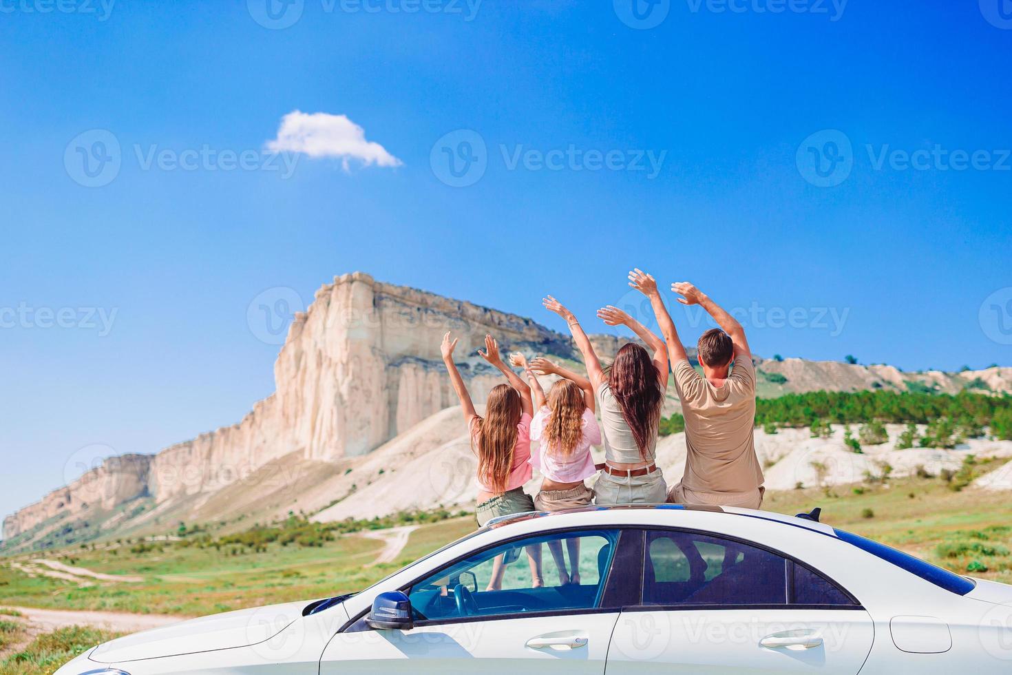 padres y dos niños pequeños en vacaciones de verano en coche foto