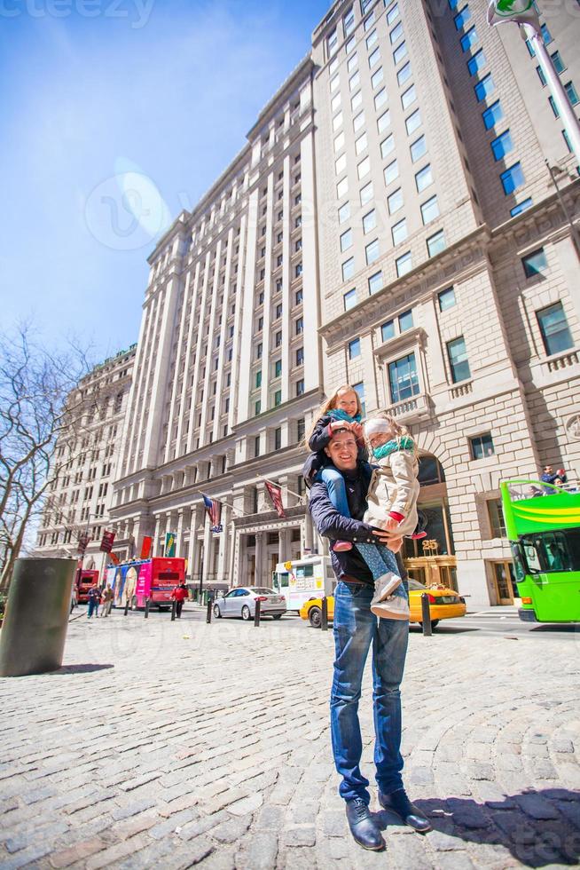 Dad with little girls on Wall Street in financial district, New York City photo