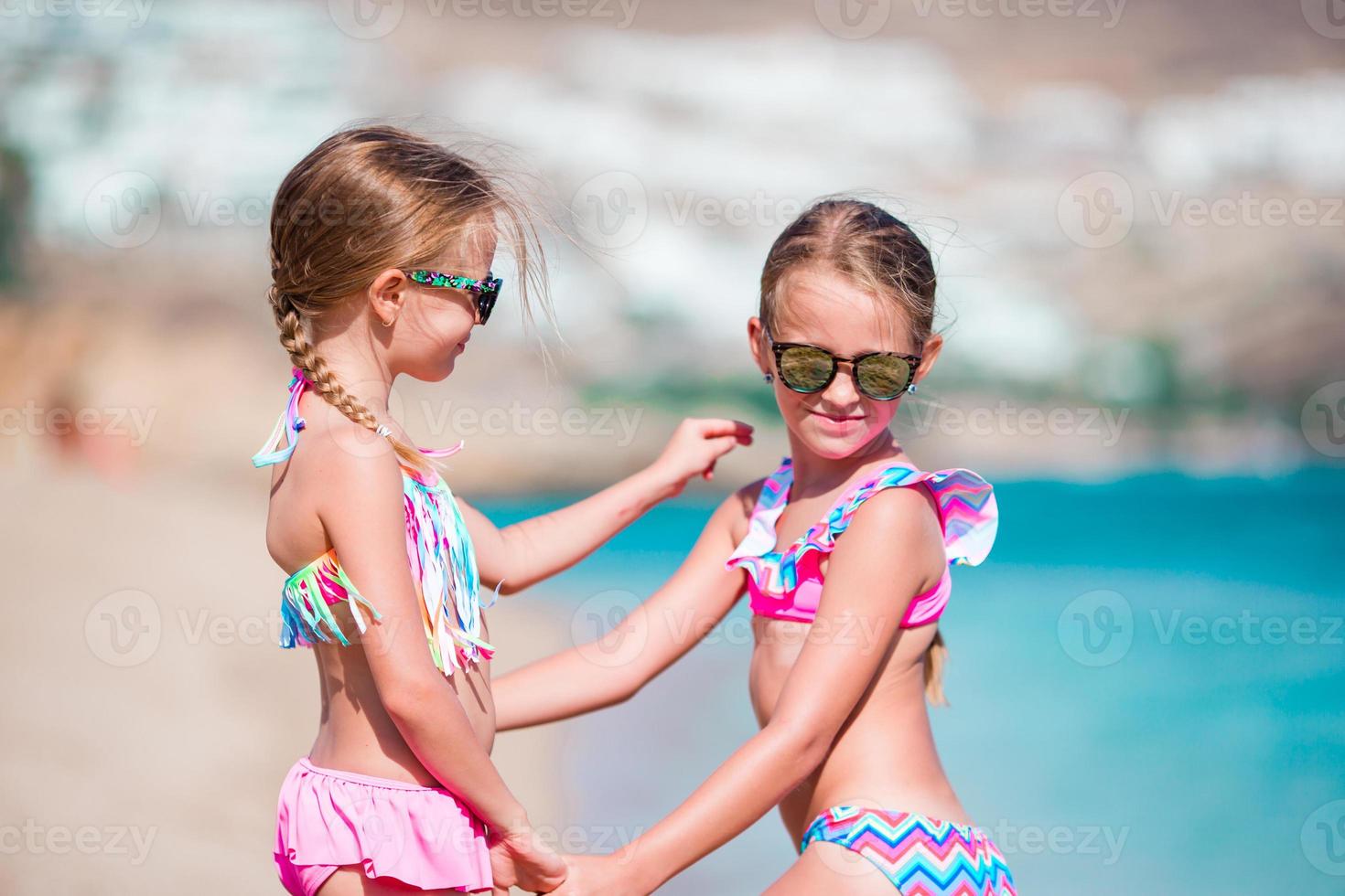 Two little girls together on the beach on caribbean vacation photo