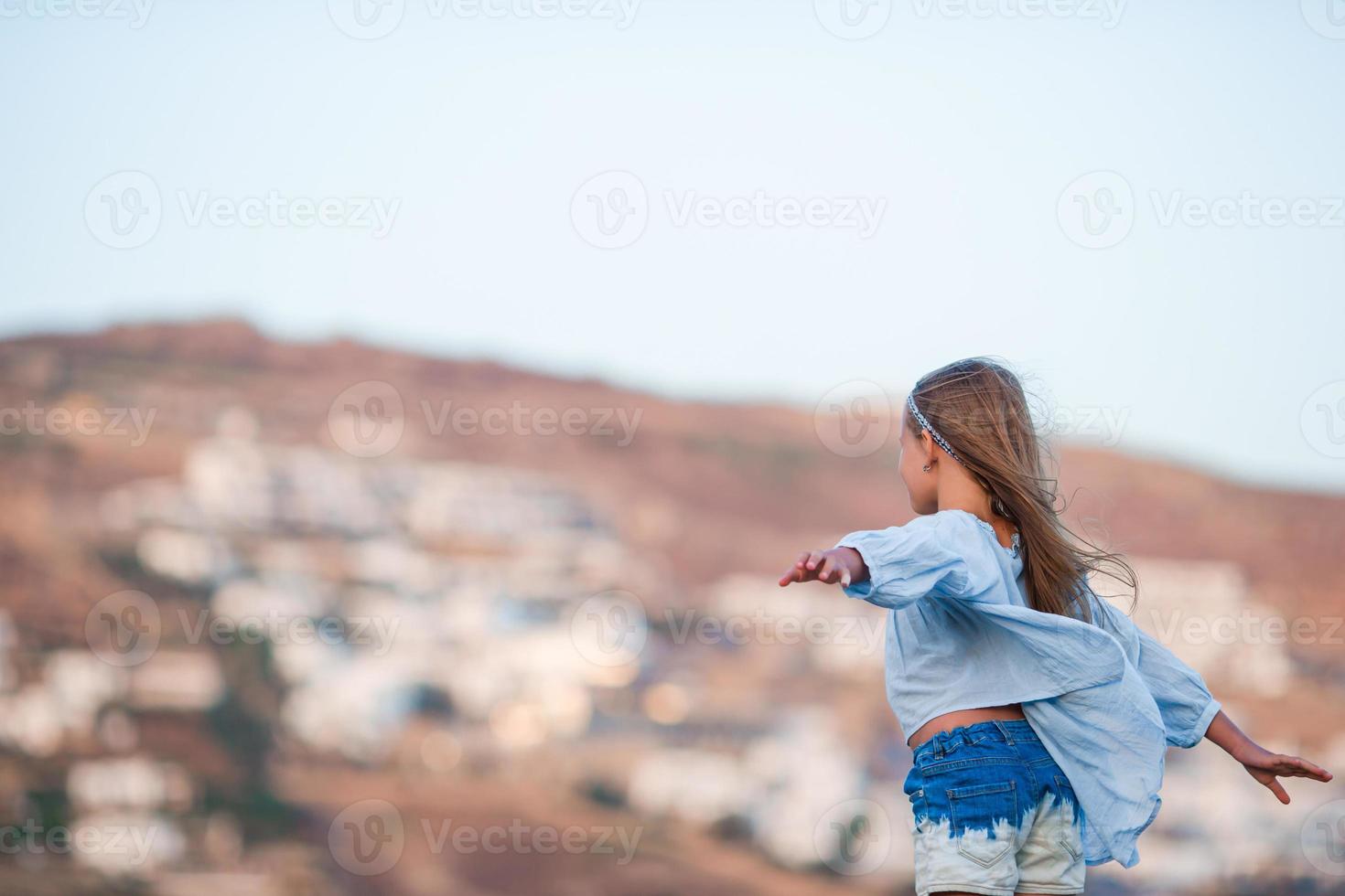 Adorable little girl in the evening with beautiful view photo