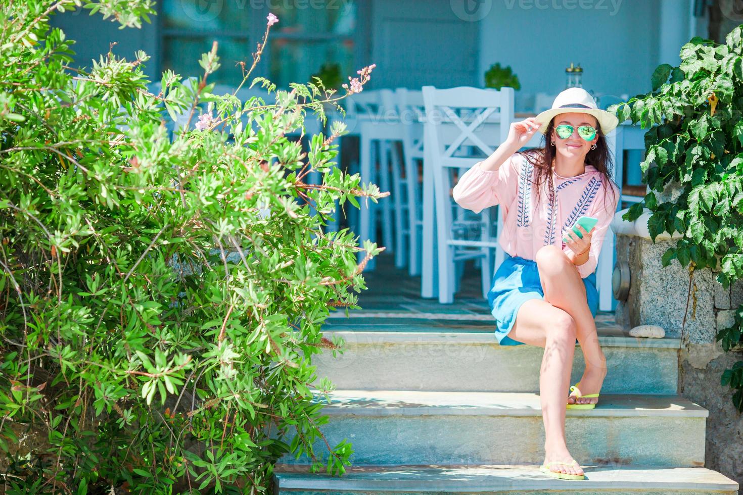 bella mujer sentada en un café de playa al aire libre foto