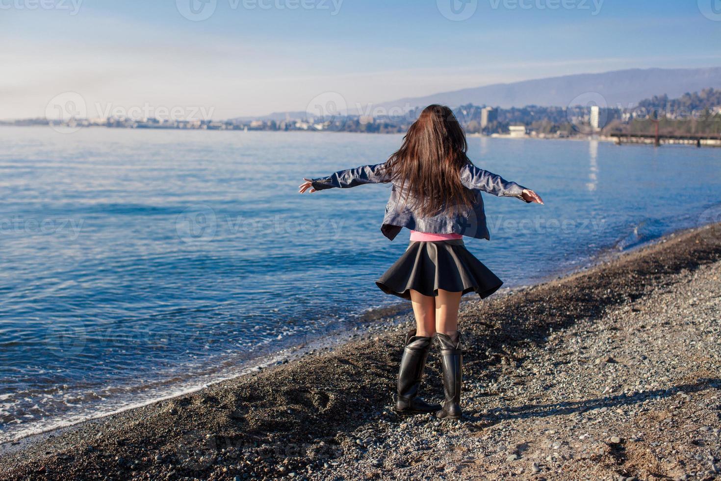 Beautiful young woman relax on the beach in winter sunny day alone photo