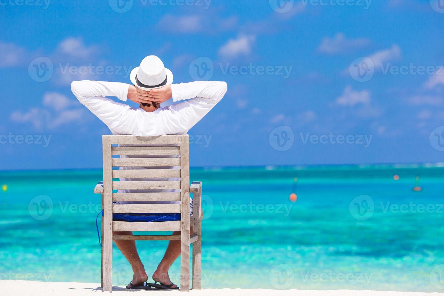 Young man enjoying summer vacation on tropical beach photo