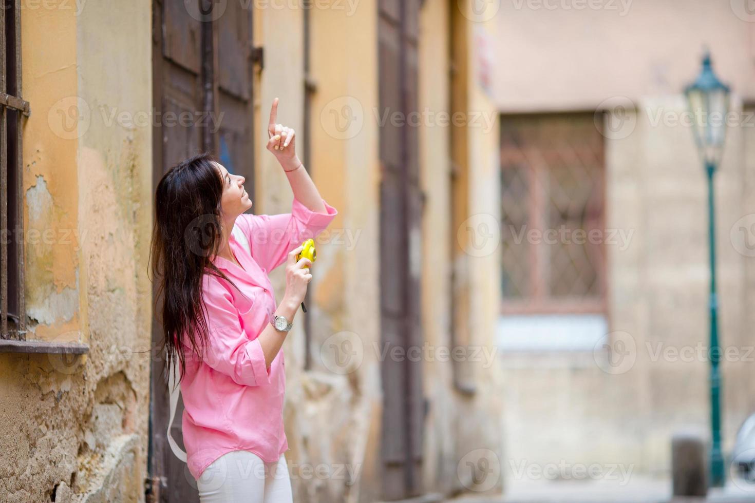 Happy young urban woman in old european streets outdoors. Caucasian tourist walking along the deserted streets of Europe. photo