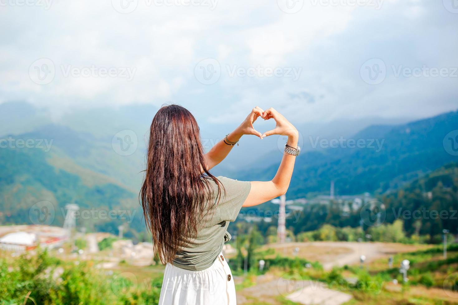 hermosa joven feliz en las montañas en el fondo de la niebla foto