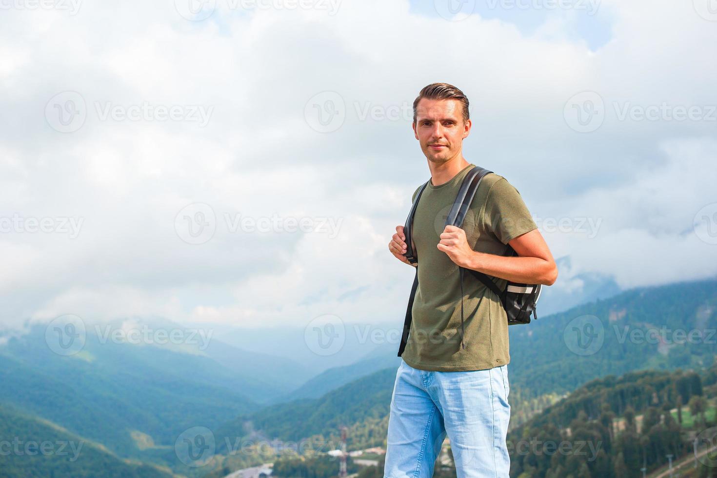 Tourist man in mountains in the background of fog photo