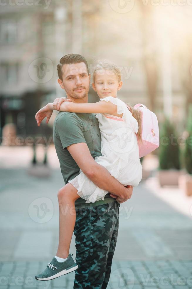 Happy dad and little adorable girl in the city outdoors photo