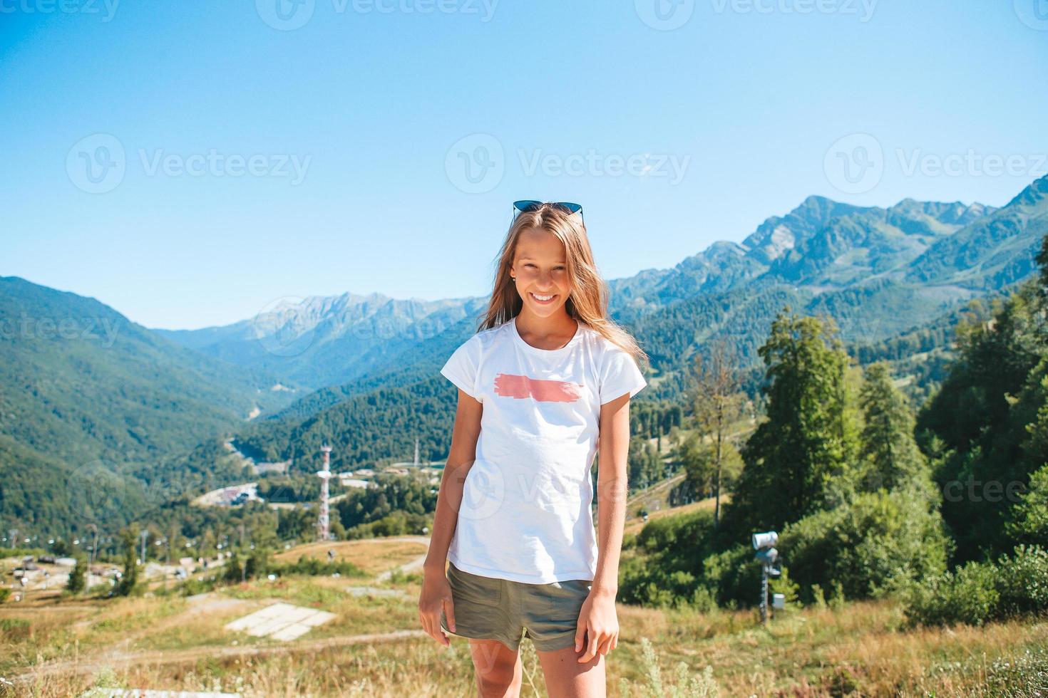 Beautiful happy little girl in mountains in the background of fog photo
