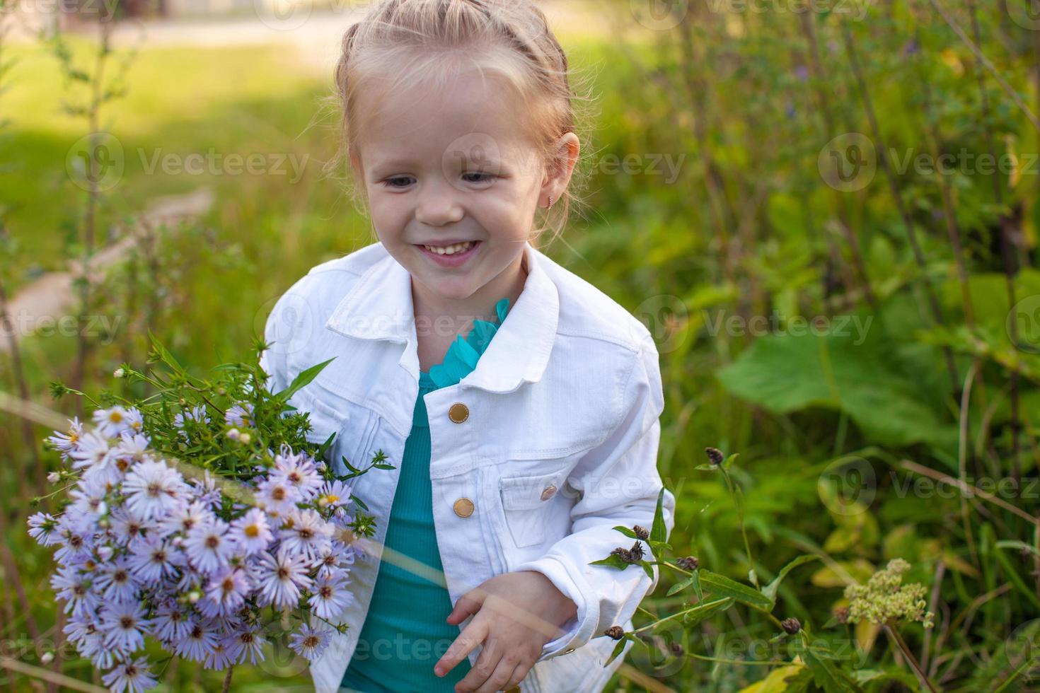 Little cute girl walking with a bouquet of flowers photo