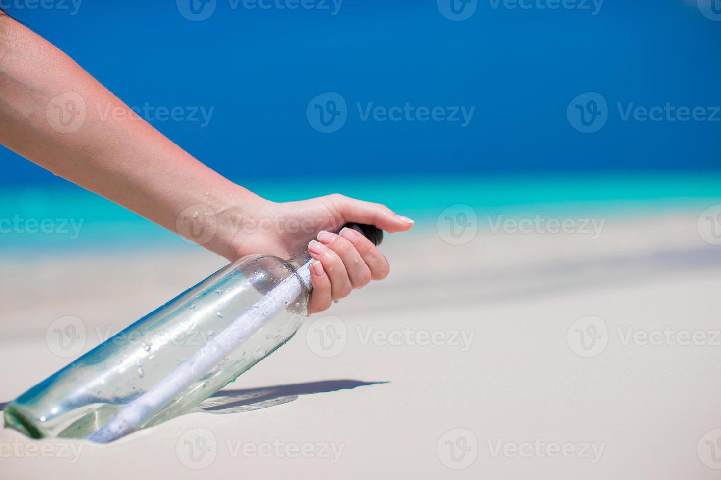 Bottle with a message buried in the white sand photo