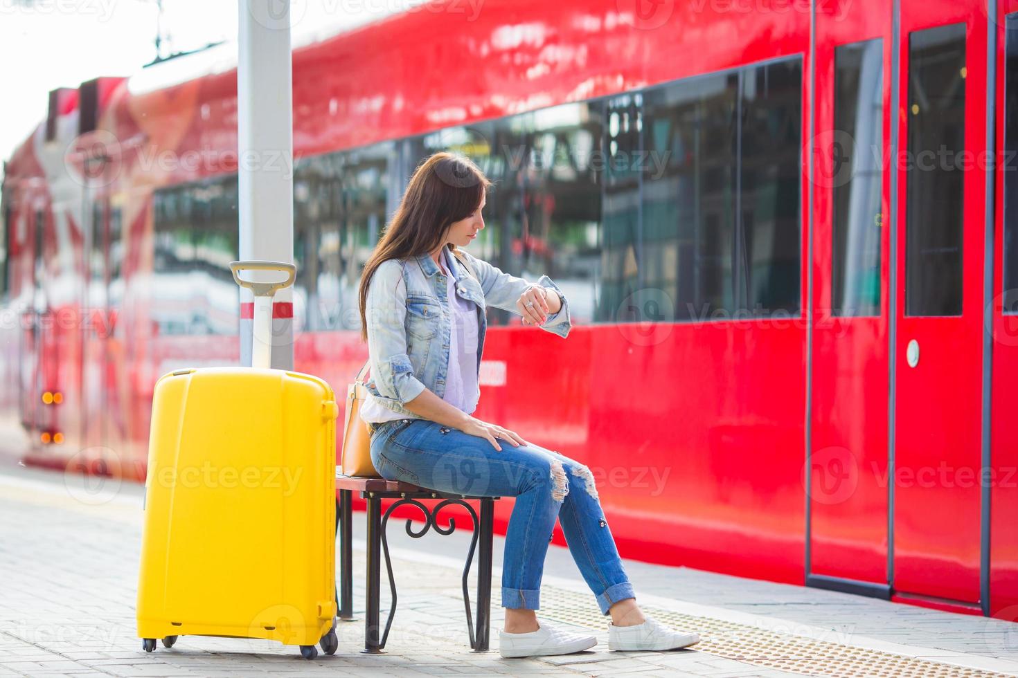 Young beautiful girl with baggage at a train station photo