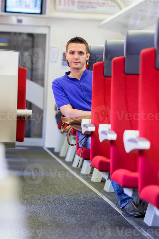 joven feliz viajando en tren foto