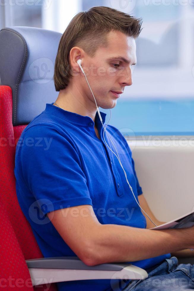 Happy caicasian tourist listening music traveling by train photo