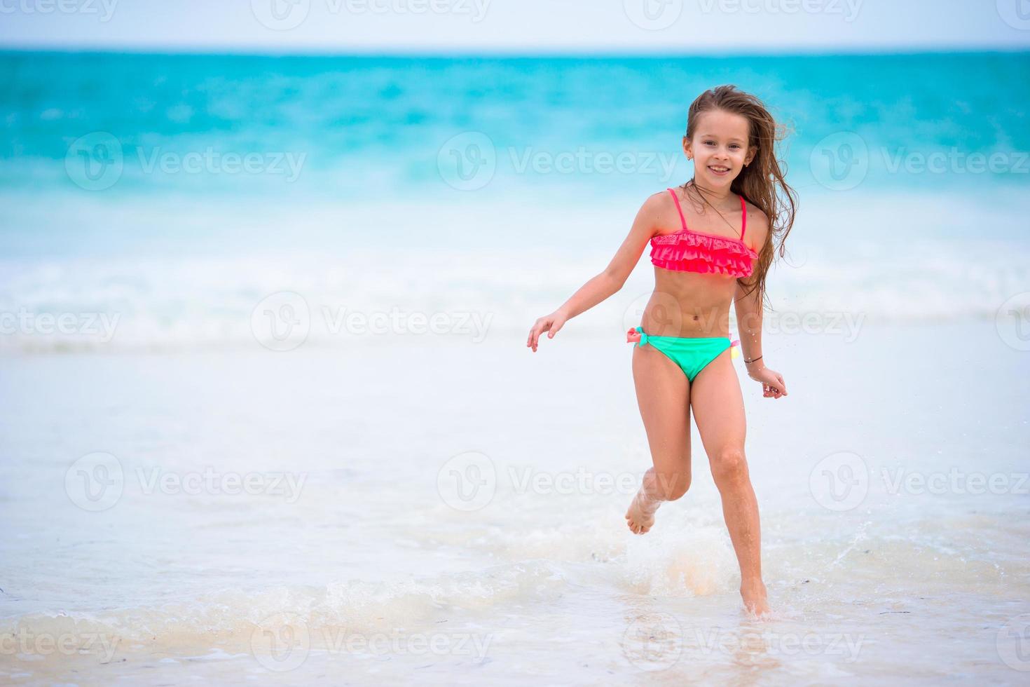 Adorable little girl at beach during summer vacation photo