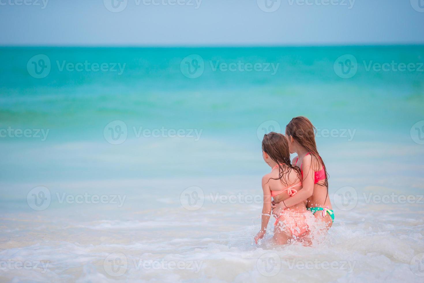 Kids having fun at tropical beach during summer vacation playing together at shallow water photo