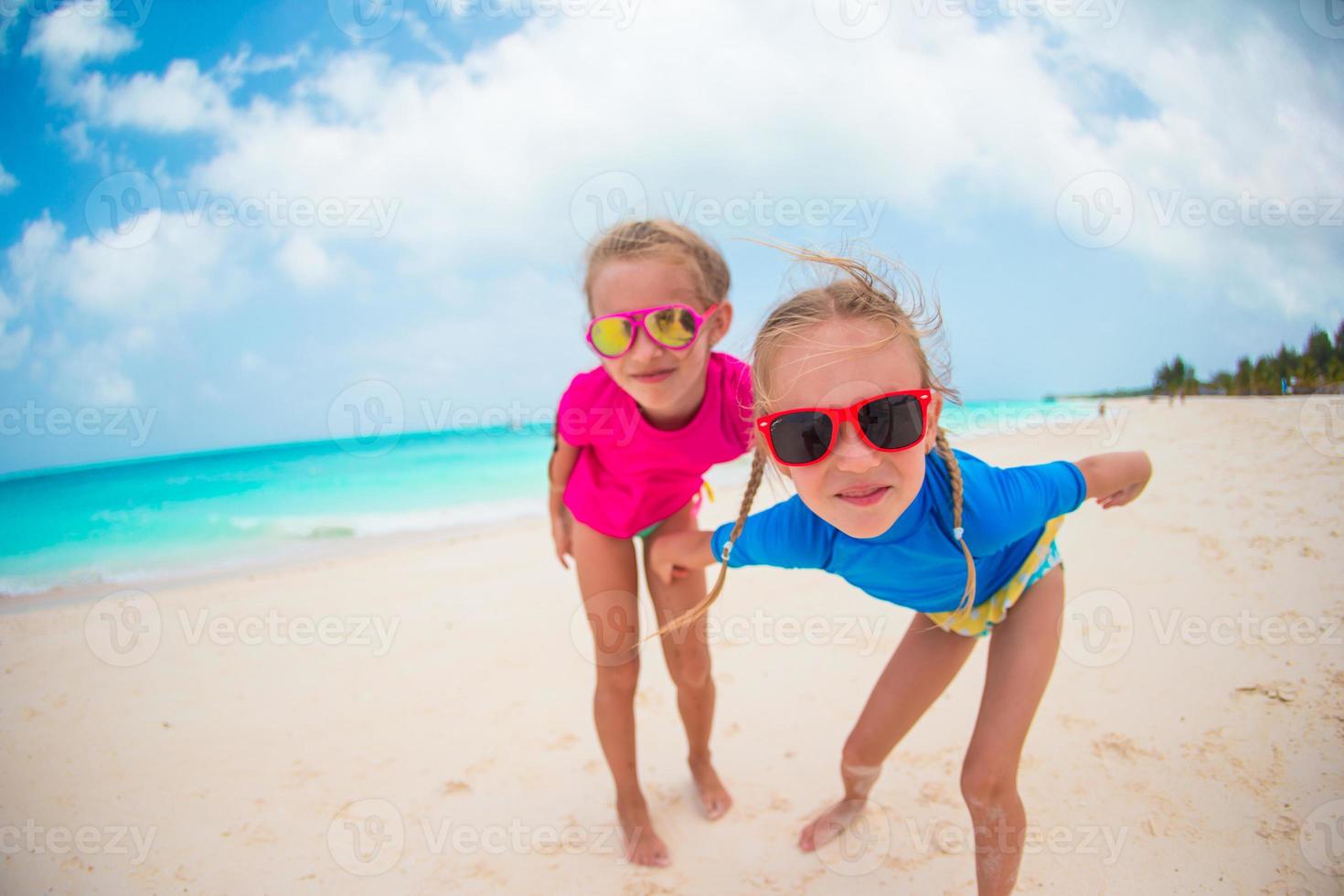 Adorable little girls at beach during summer vacation photo