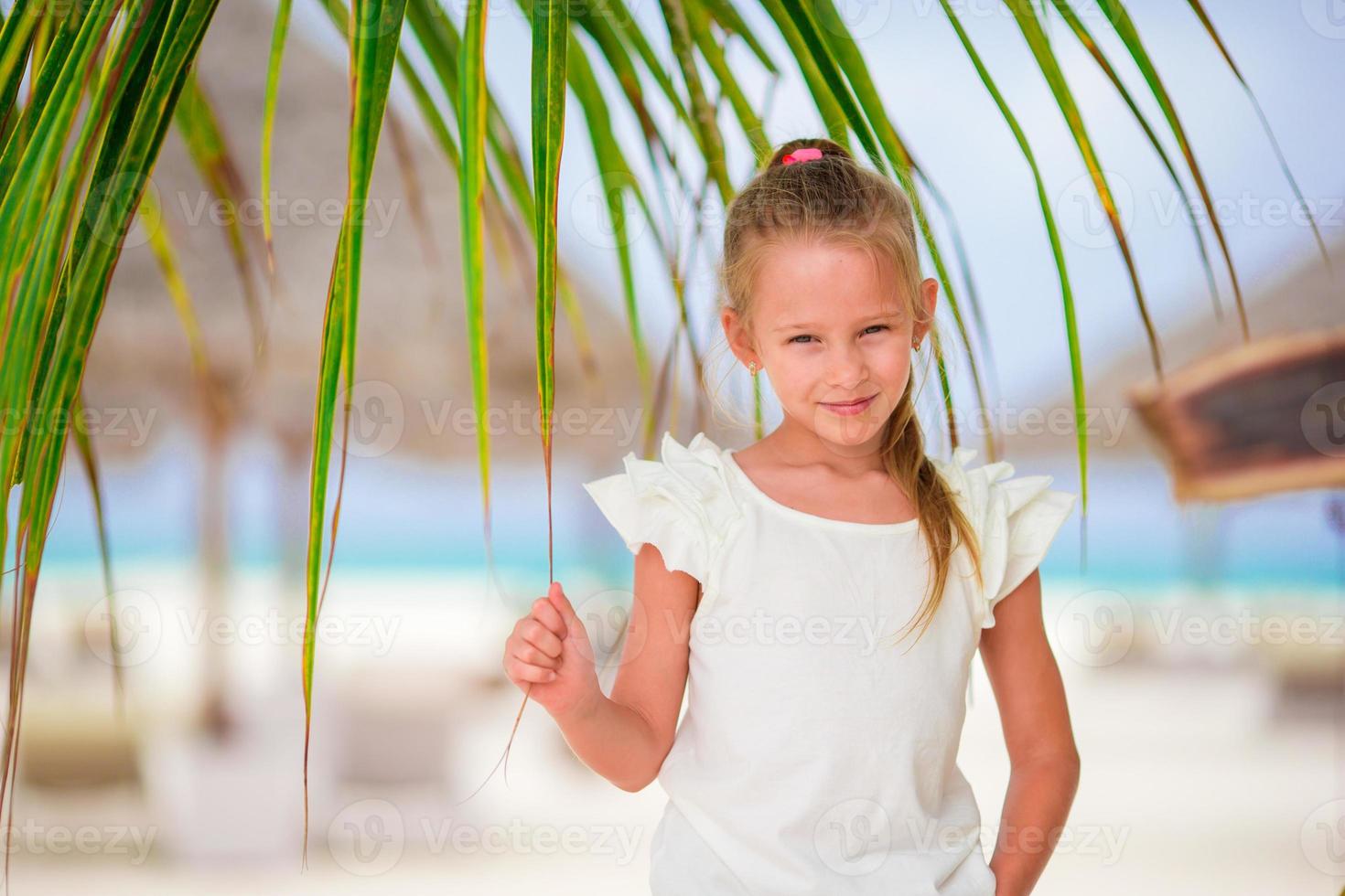 Adorable little girl at beach during summer vacation photo