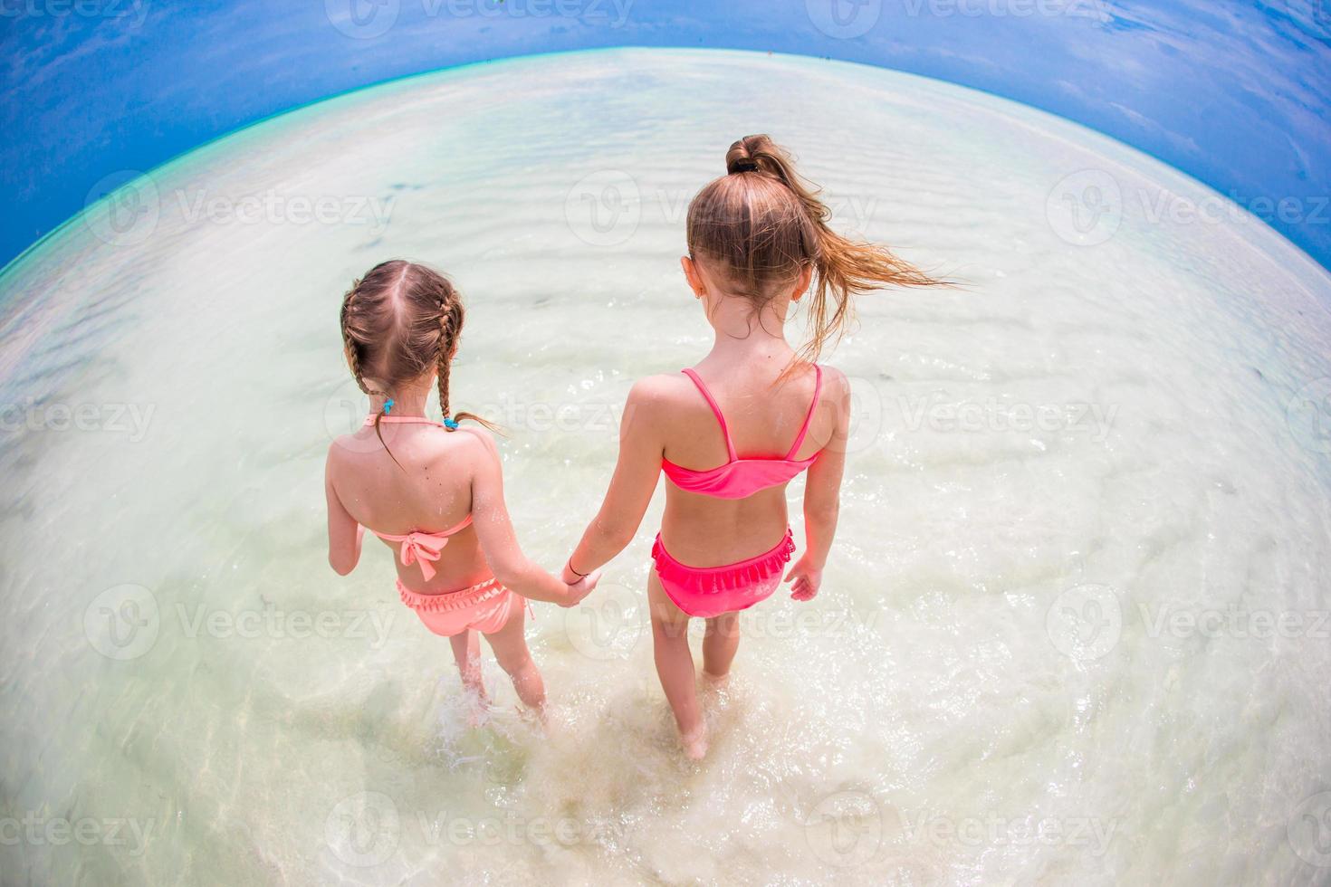 adorables niñas en la playa durante las vacaciones de verano foto