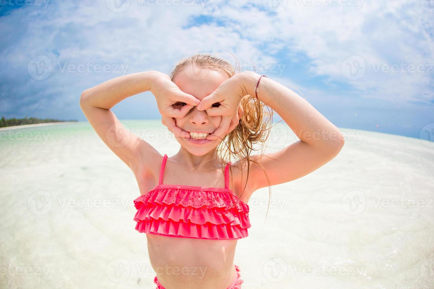 Adorable little girl having fun like as a superhero at beach photo