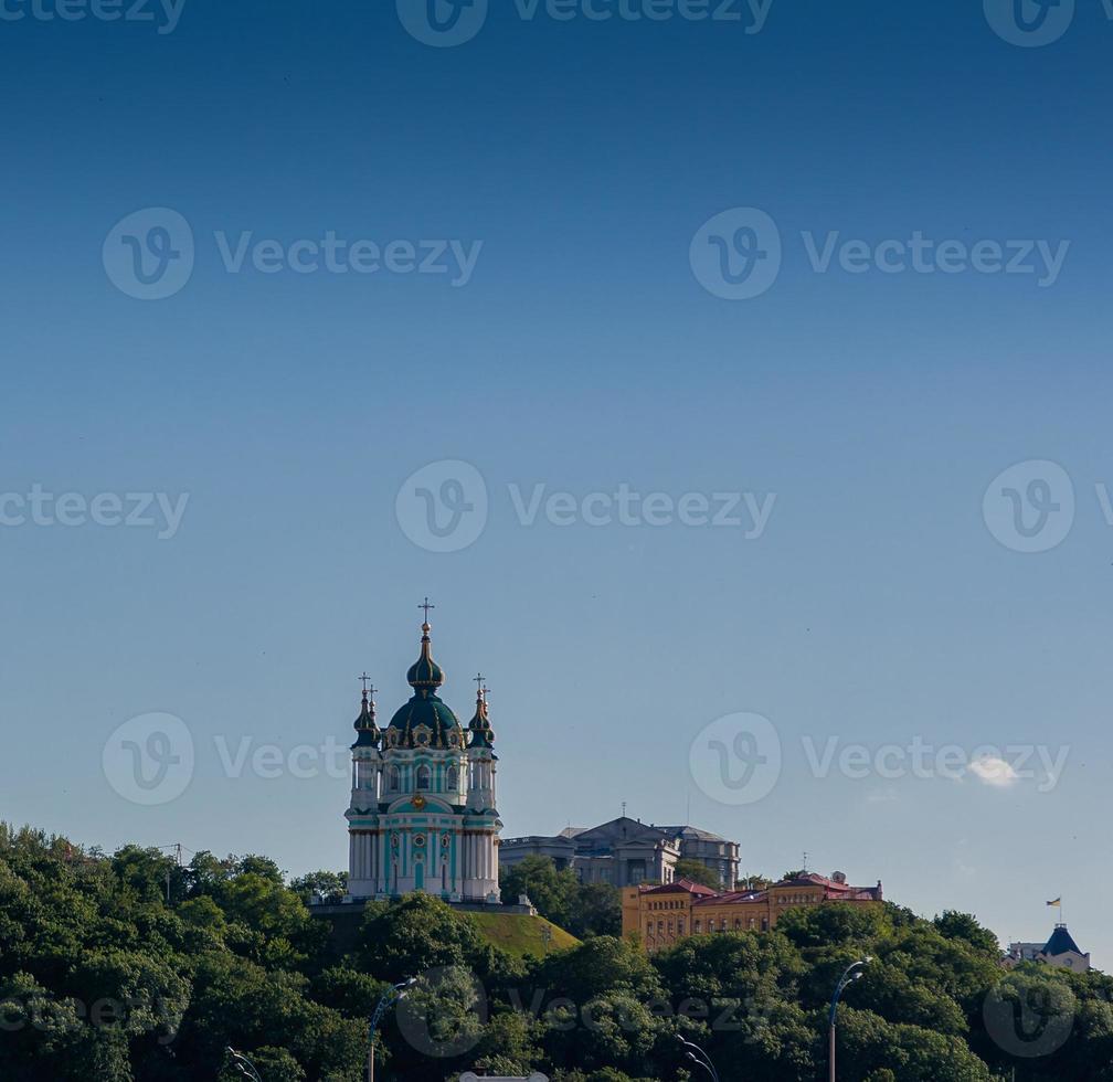 hermosa iglesia en una montaña con árboles contra un fondo de cielo azul foto