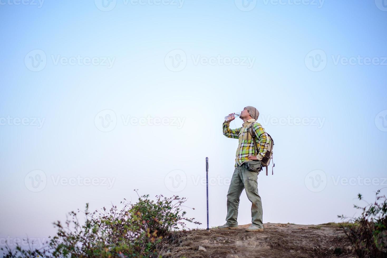 Portrait of Hiker man with backpack drinking water photo