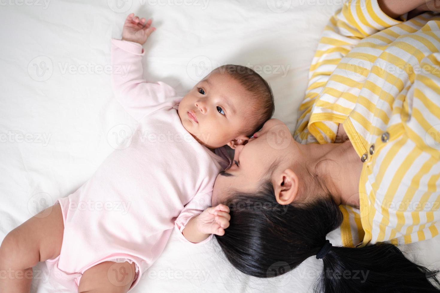 crianza de la madre y vida del nacimiento del recién nacido. mamá y bebé jugando en un dormitorio soleado, familia divirtiéndose juntos. cuidado de niños, concepto de maternidad. foto