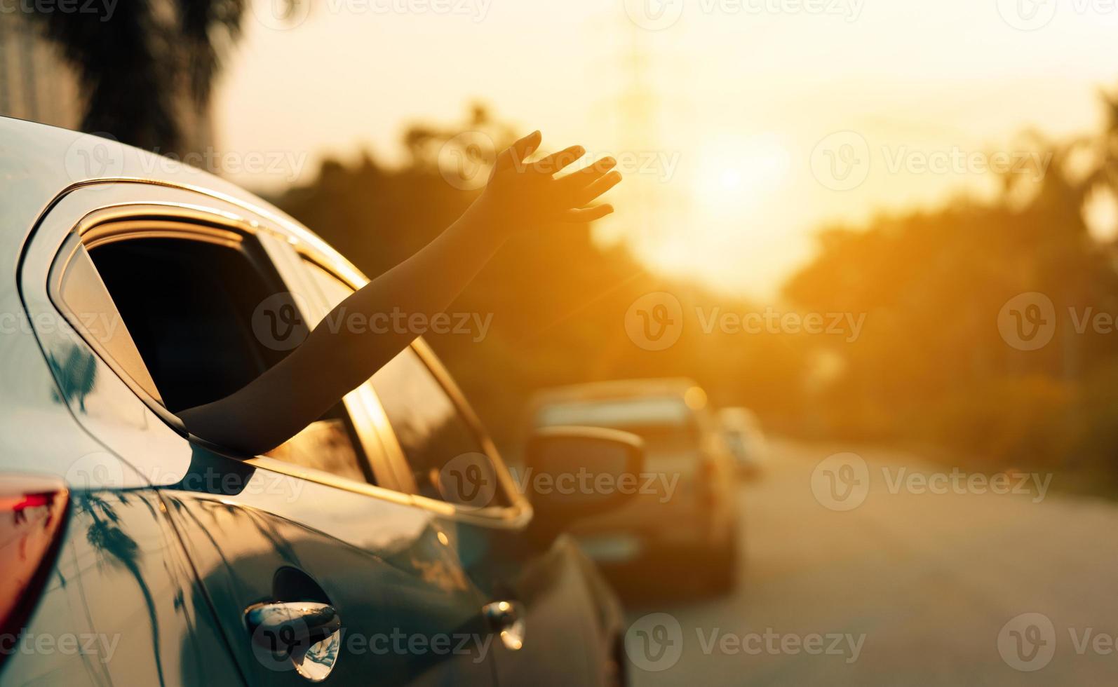 viaje en automóvil hatchback conduciendo un viaje por carretera de una mujer de vacaciones de verano en un automóvil azul al atardecer, las niñas felices viajando disfrutan de las vacaciones y la relajación con amigos juntos consiguen la atmósfera e van al destino foto