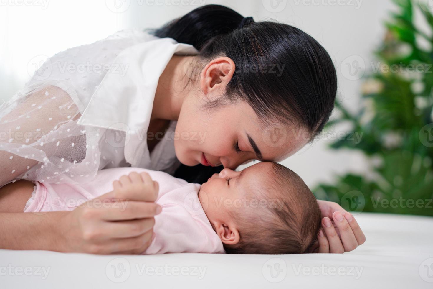 crianza de la madre y vida del nacimiento del recién nacido. mamá y bebé jugando en un dormitorio soleado, familia divirtiéndose juntos. cuidado de niños, concepto de maternidad. foto