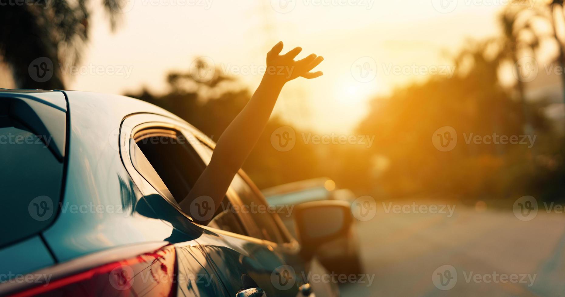 viaje en automóvil hatchback conduciendo un viaje por carretera de una mujer de vacaciones de verano en un automóvil azul al atardecer, las niñas felices viajando disfrutan de las vacaciones y la relajación con amigos juntos consiguen la atmósfera e van al destino foto