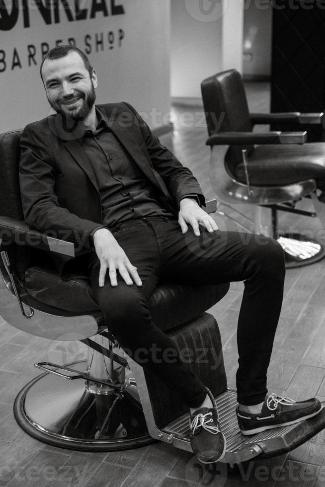 bearded man cutting his beard in the barbershop photo