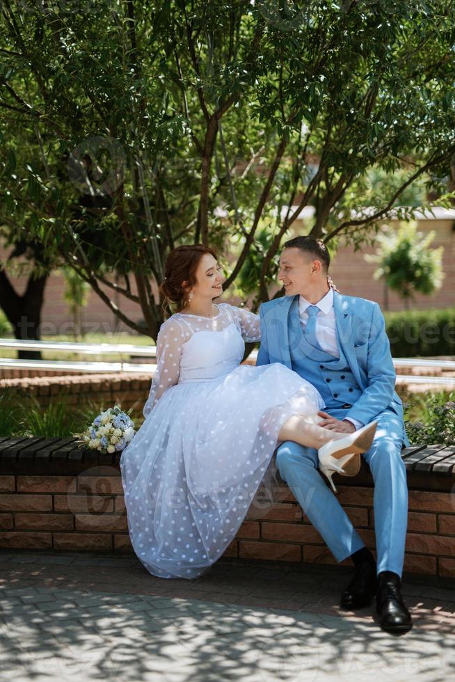 novia con un vestido de novia ligero al novio con un traje azul foto