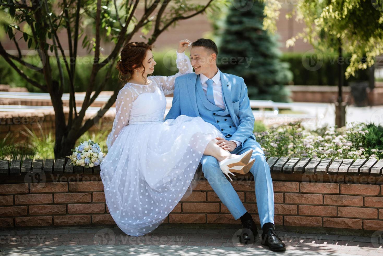 bride in a light wedding dress to the groom in a blue suit photo